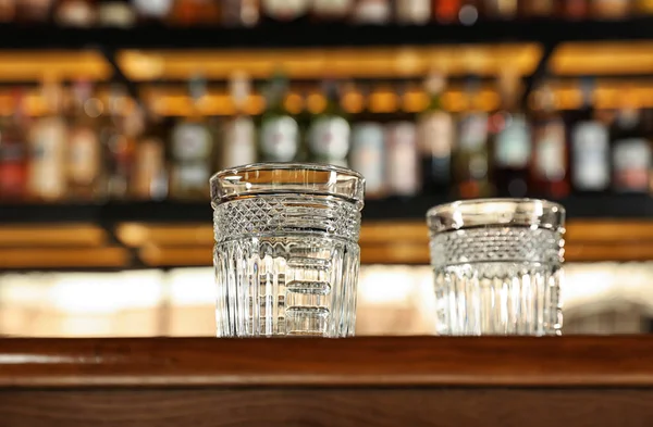 Пустые чистые стаканы на стойке в современном баре, вид с низким углом — стоковое фото