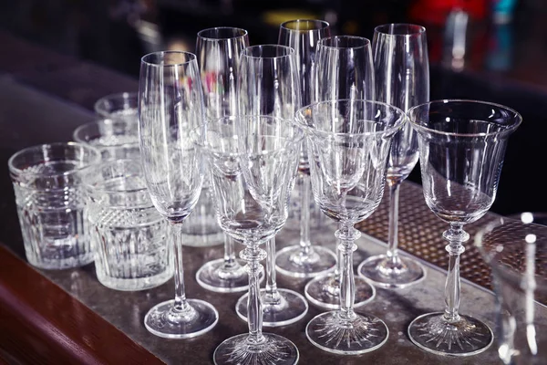 Different empty clean glasses on counter in bar — Stock Photo, Image