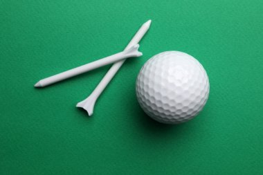 Golf topu ve renk arka plan üzerinde tees, düz yatıyordu. Spor ekipmanları