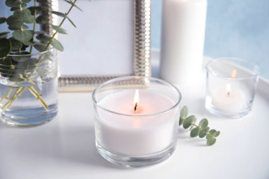 Masa üzerinde aromatik mum ve okaliptüs dalı yanma