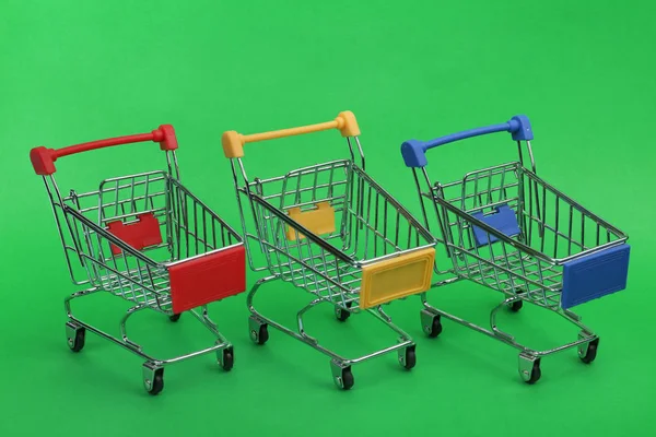 Fila de carros de compras vacíos sobre fondo de color — Foto de Stock