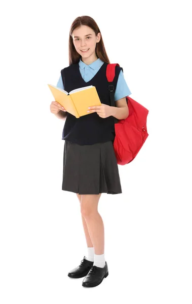Teljes hosszúságú portréja tizenéves lány az iskolában egységes hátizsák és könyv fehér háttér — Stock Fotó