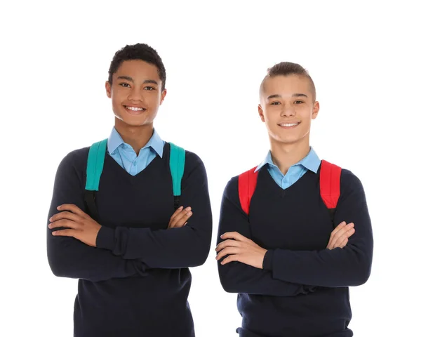 Tizenéves fiúk portré az iskolában egységes a hátizsákok fehér alapon — Stock Fotó