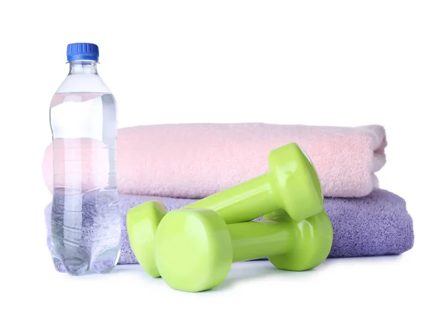 Stylové činky, láhev vody a ručníky na bílém podkladu. Fitness domácí — Stock fotografie