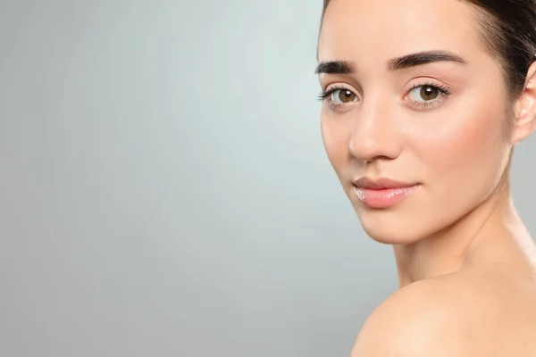 Portret van jonge vrouw met mooi gezicht tegen kleur achtergrond. Ruimte voor tekst — Stockfoto