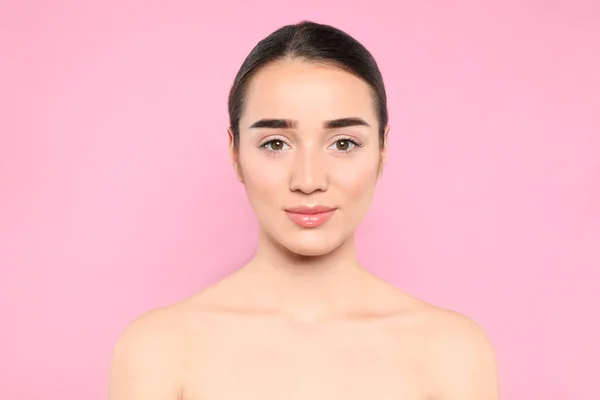 Portrét mladé ženy s krásnou tváří proti barevnému pozadí — Stock fotografie