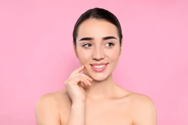 Portret van jonge vrouw met mooi gezicht tegen kleur achtergrond — Stockfoto