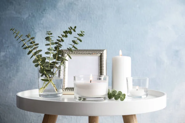 Komposisi dengan lilin aromatik yang terbakar di atas meja di dekat dinding warna — Stok Foto