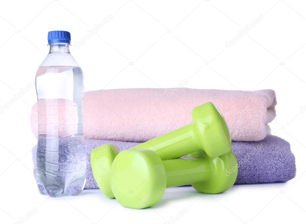 Stylish dumbbells, bottle of water and towels on white background. Home fitness