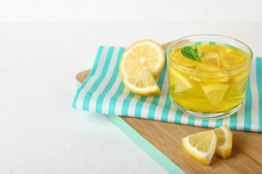 Beyaz masada bir bardak limon jölesi servis edilir. Metin için alan