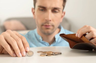 Üzgün adam masada cüzdaniçine para koyarak