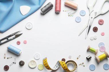 Beyaz arka planda makas ve dikiş malzemeleri ile düz yatıyordu kompozisyon. Metin alanı