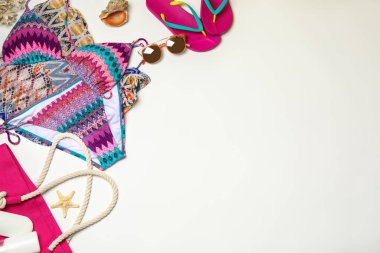 Beyaz arka planda mayo ve plaj aksesuarları ile düz yatıyordu kompozisyon. Metin için alan