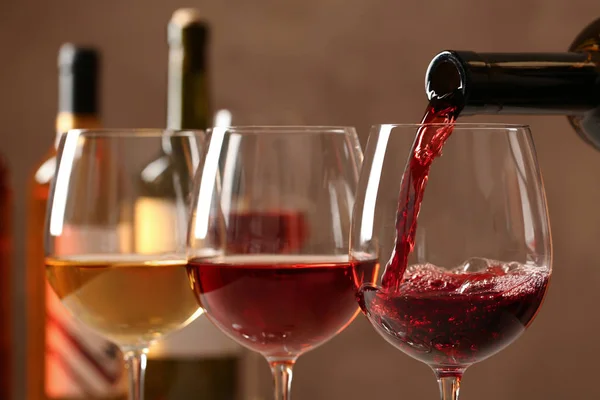 Наливаючи вино з пляшки в склянку на розмитому фоні, крупним планом — стокове фото