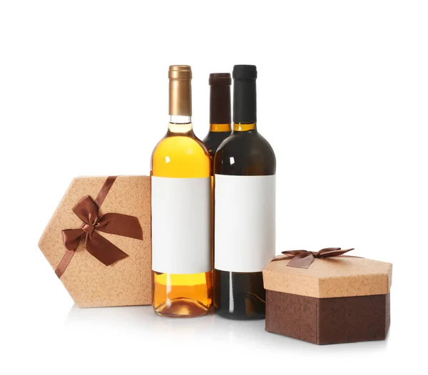 Бутылки вина и подарочные коробки на белом фоне — стоковое фото