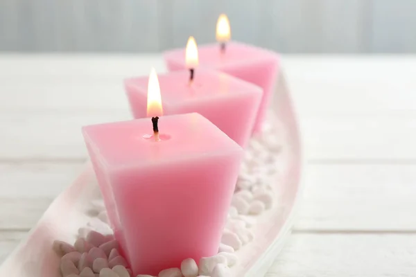 Состав с тремя горящими свечами на белом столе — стоковое фото