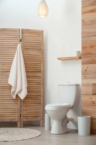 Toilettenschüssel nahe weißer Wand in modernem Badezimmerinnenraum — Stockfoto