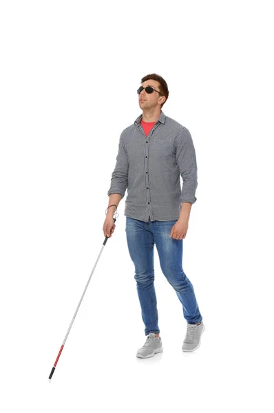 Young blind person with long cane walking on white background — Stock Photo, Image