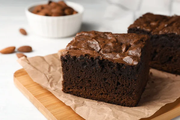 Placa de madeira com brownies frescos na mesa, espaço para texto. Deliciosa torta de chocolate — Fotografia de Stock