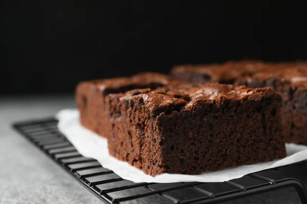 Холодильная стойка со свежими брауни на сером столе, место для текста. Вкусный шоколадный пирог — стоковое фото