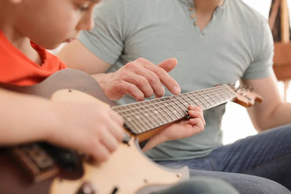 Niño tocando la guitarra con su profesor en la clase de música, primer plano. Notas de aprendizaje — Foto de Stock
