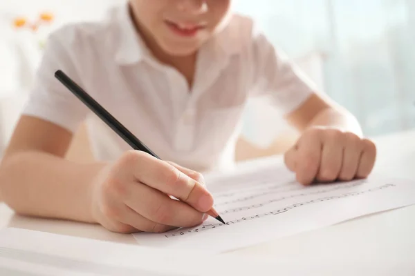 Ragazzino che scrive note musicali a tavola, primo piano — Foto Stock