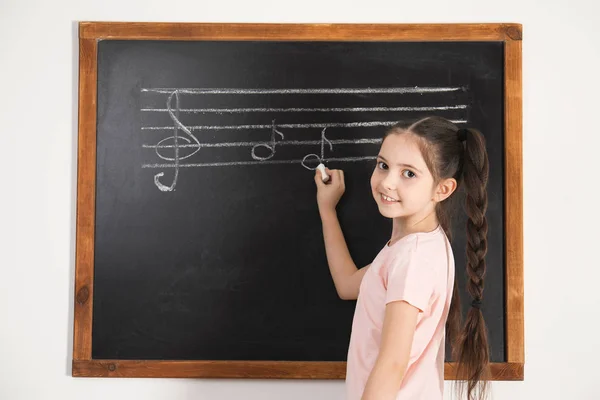 Little Girl pisanie nut na tablicy w klasie — Zdjęcie stockowe