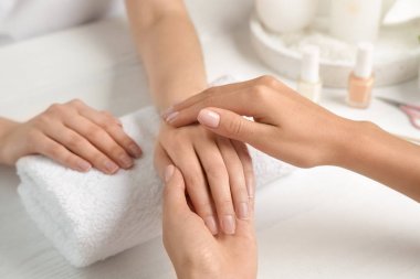 Spa salonunda masada müşterinin elini masaj kozmetolog, closeup