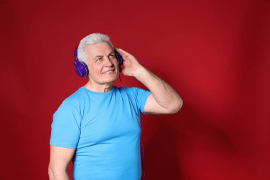 Olgun adam renkli arka plan üzerinde kulaklık müzik zevk. Metin için alan
