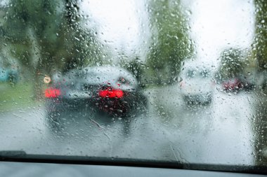 Blurred view of road through wet car window. Rainy weather clipart