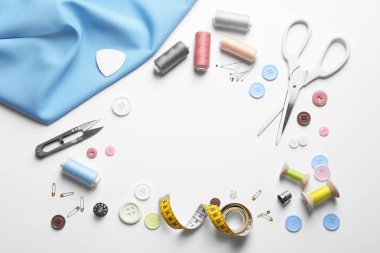 Beyaz arka planda makas ve dikiş malzemeleri ile düz yatıyordu kompozisyon. Metin alanı