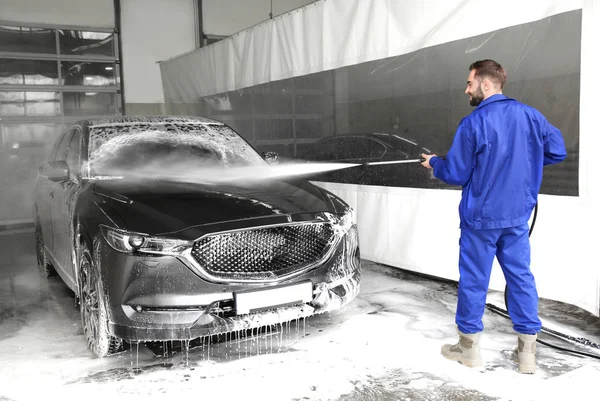 Trabalhador de limpeza automóvel com jato de água de alta pressão na lavagem do carro — Fotografia de Stock