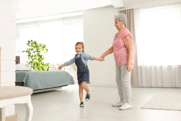 Roztomilá dívka s babičkou tančí doma — Stock fotografie