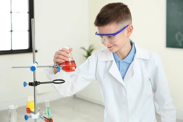 Uśmiechnięty uczeń patrząc na kolbę z odczynnikiem w klasie chemii — Zdjęcie stockowe