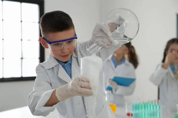 Smart skolpojke göra experiment i kemi klass — Stockfoto