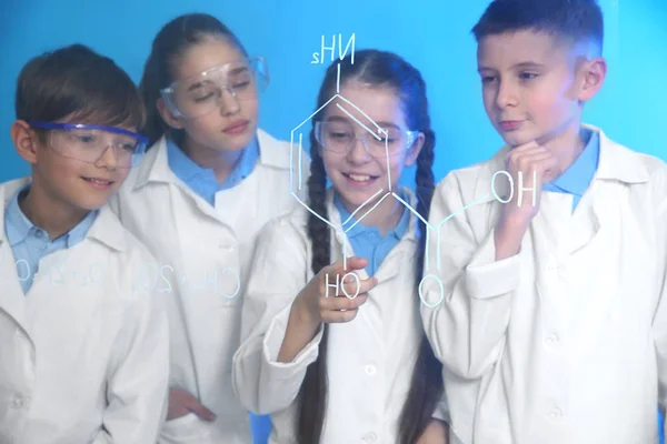 Žáci, kteří studují chemický vzorec na skleněné desce proti barevnému pozadí — Stock fotografie