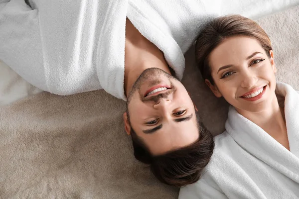 Happy young couple wearing bathrobes, top view. Visit to spa salon — Stock Photo, Image