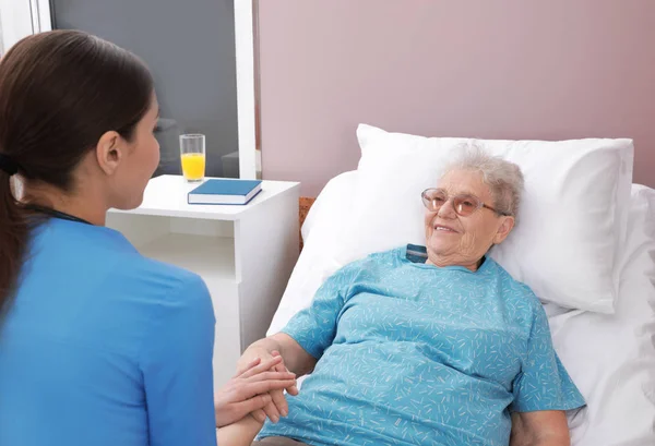 Krankenschwester hilft Seniorin auf Krankenhausstation — Stockfoto