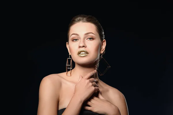 Retrato de hermosa dama con lápiz labial de oro sobre fondo negro — Foto de Stock