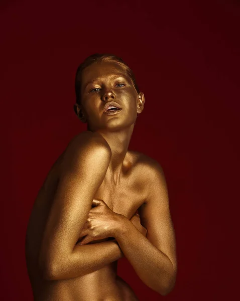 Retrato de bela senhora com tinta dourada na pele contra fundo de cor — Fotografia de Stock