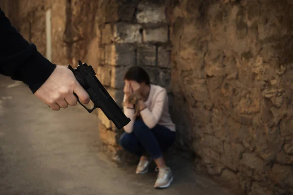 Un homme armé tenant une femme en otage à l'extérieur, se concentrant sur la main avec une arme. Infraction pénale — Photo