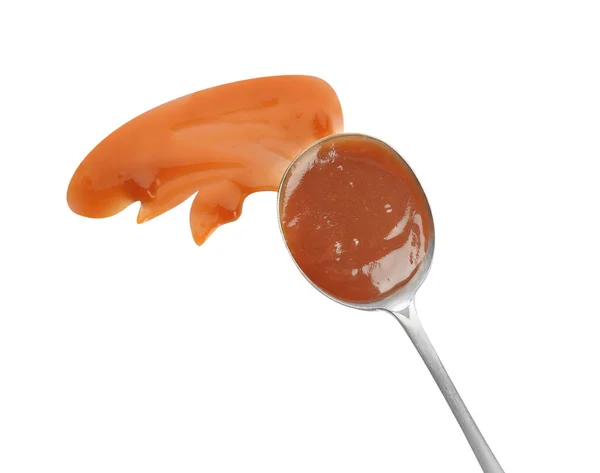 Cucchiaio e colpi di salsa al caramello isolati su bianco, vista dall'alto — Foto Stock