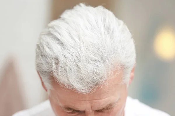 Старший мужчина с проблемой выпадения волос в помещении, крупный план — стоковое фото