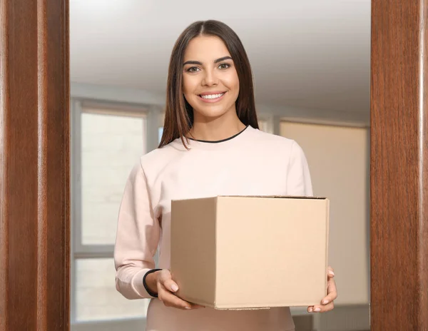 Портрет улыбающейся женщины с посылкой у двери, макет для дизайна. Служба доставки — стоковое фото