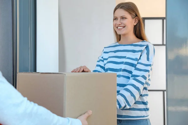 Frau erhält Paket von Zustelldienst-Kurier im Haus — Stockfoto