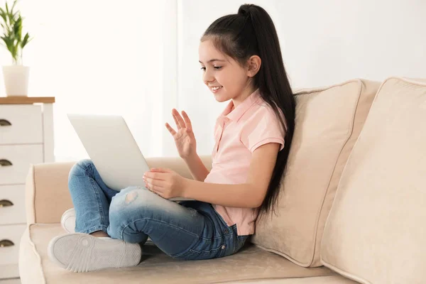 Ragazzina che utilizza la video chat sul computer portatile a casa — Foto Stock