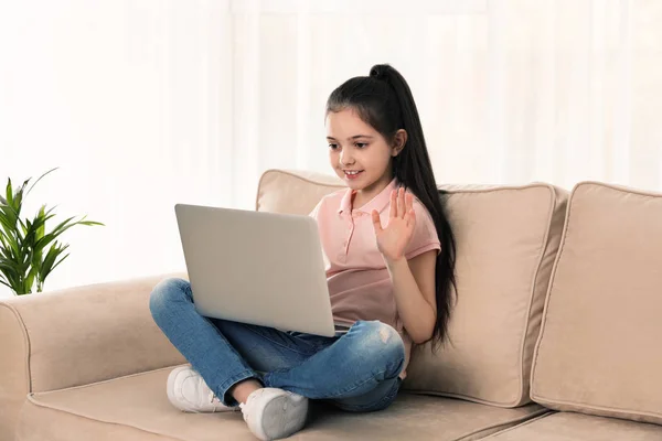 Mała dziewczynka za pomocą czatu wideo na laptopie w domu — Zdjęcie stockowe