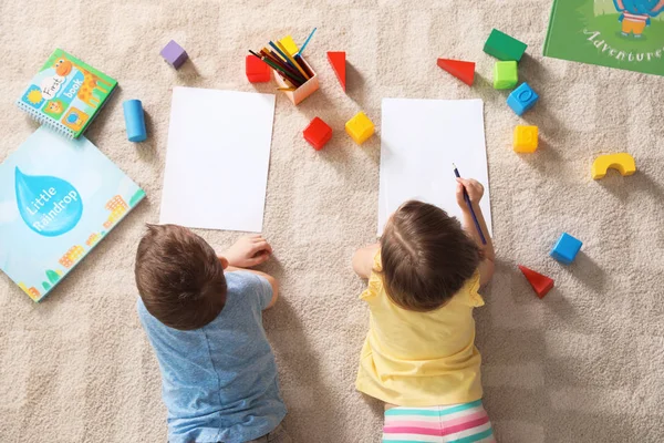 Kleine kinderen tekenen binnenshuis, Top uitzicht. Leren en spelen — Stockfoto