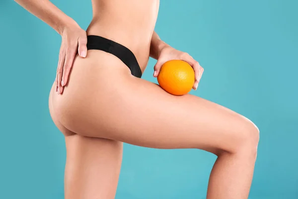 Closeup view of slim woman in underwear with orange on color background. Cellulite problem concept — Stock Photo, Image