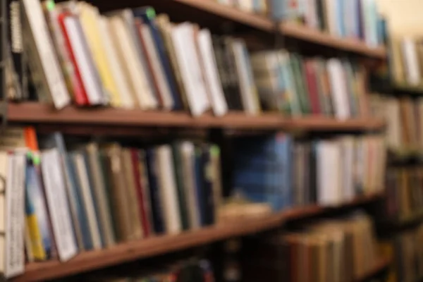 Vista borrosa de los estantes con libros en la biblioteca —  Fotos de Stock